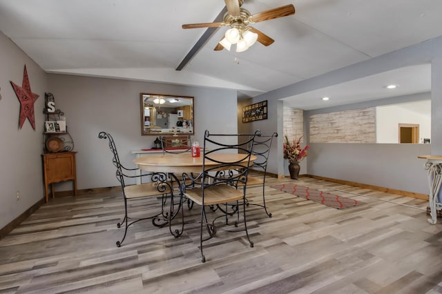 dining space featuring vaulted ceiling with beams, ceiling fan, and light hardwood / wood-style flooring