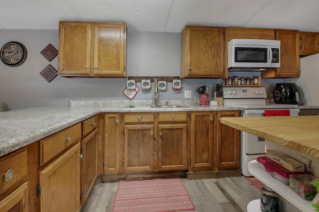 kitchen featuring white appliances, light hardwood / wood-style floors, and sink