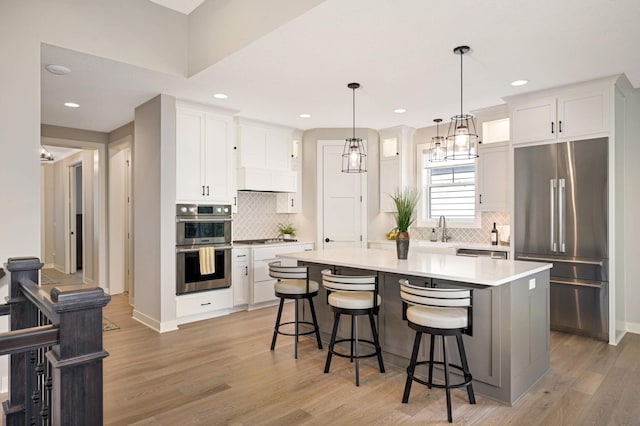 kitchen featuring white cabinetry, a kitchen island, a breakfast bar area, and appliances with stainless steel finishes