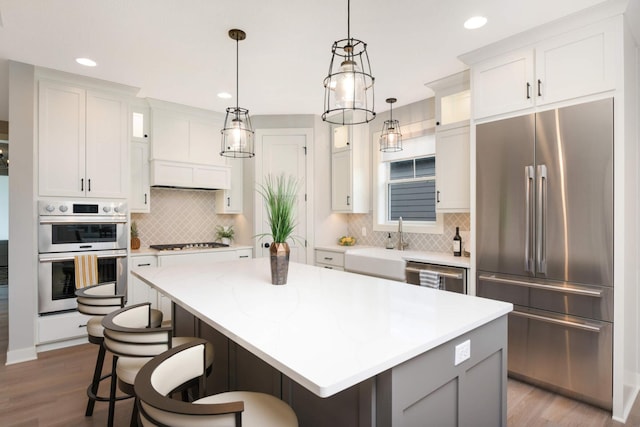 kitchen with stainless steel appliances, a center island, and white cabinets