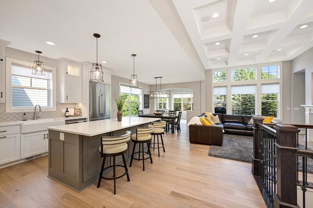 kitchen with sink, a spacious island, white cabinets, and appliances with stainless steel finishes