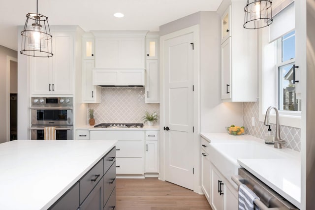 kitchen featuring sink, gray cabinetry, white cabinetry, decorative light fixtures, and appliances with stainless steel finishes