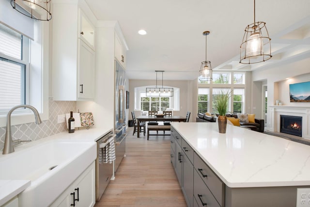 kitchen with gray cabinetry, decorative light fixtures, white cabinets, and a kitchen island