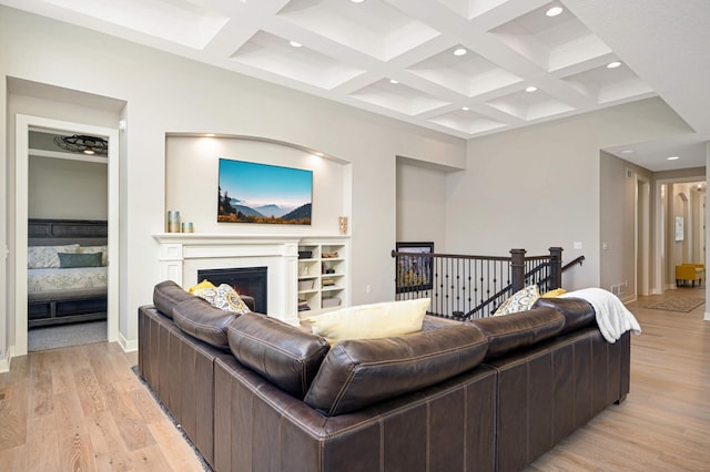 living room with beamed ceiling, coffered ceiling, and light hardwood / wood-style flooring