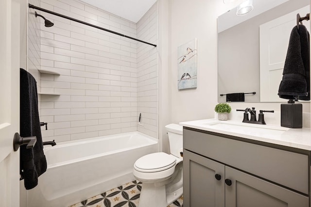 full bathroom with tiled shower / bath, vanity, and toilet