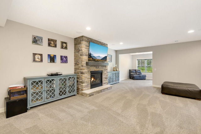 carpeted living room featuring a stone fireplace