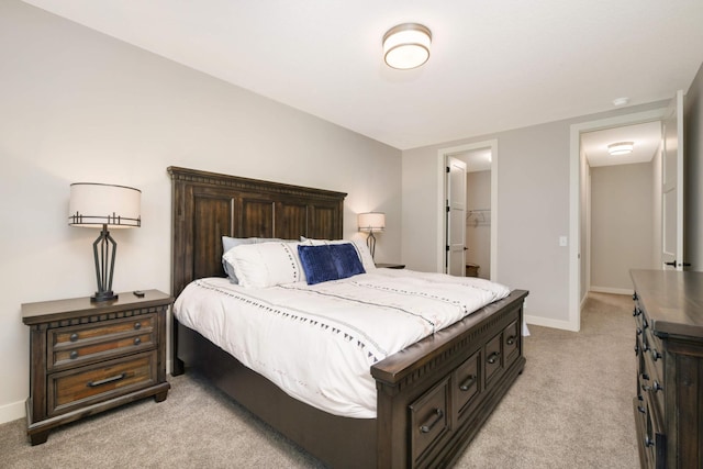 bedroom featuring a spacious closet and light colored carpet