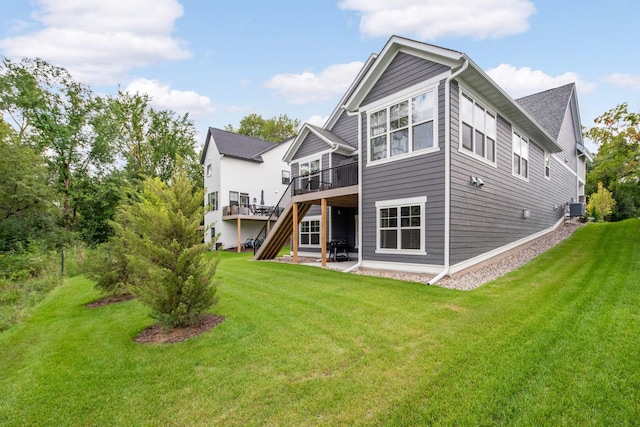 back of property featuring a wooden deck, a patio, central air condition unit, and a lawn