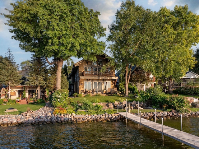 view of dock with a yard and a water view