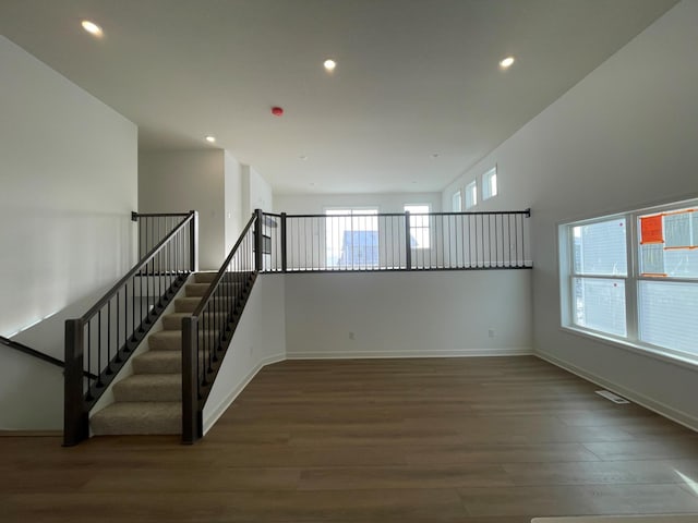 interior space featuring hardwood / wood-style floors and a towering ceiling