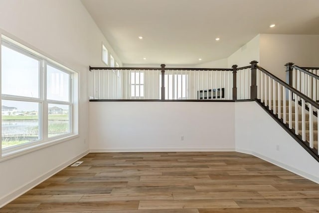 spare room with hardwood / wood-style flooring and a high ceiling