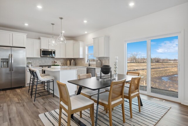 dining space featuring sink and light hardwood / wood-style floors