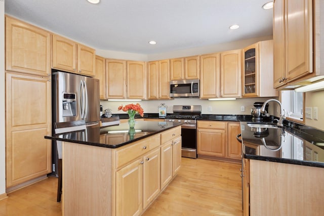 kitchen featuring stainless steel appliances, a kitchen island, and light brown cabinets