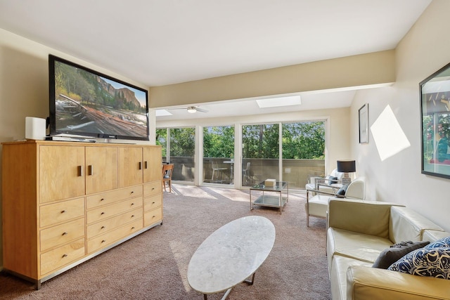 living room featuring ceiling fan, plenty of natural light, a skylight, and carpet floors