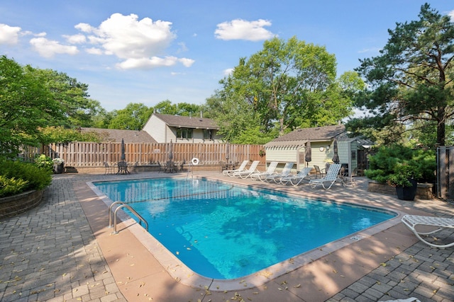 view of pool with an outbuilding and a patio