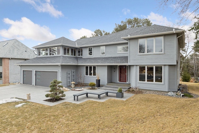 view of front of house with a shingled roof, driveway, and a front lawn