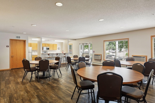 dining room featuring dark wood-type flooring and a textured ceiling