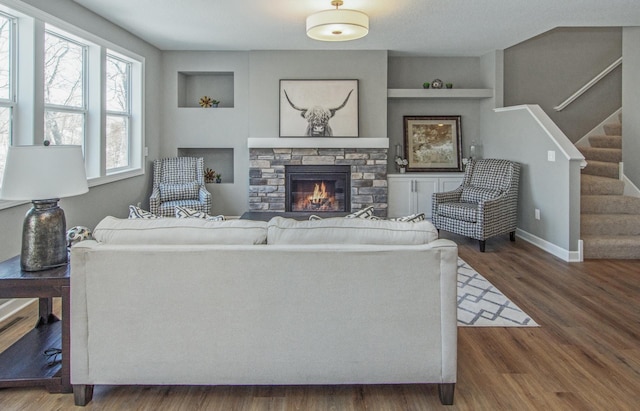 living room featuring dark hardwood / wood-style flooring, a fireplace, and built in features