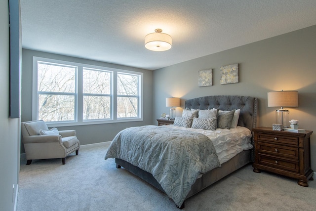 bedroom featuring light carpet and a textured ceiling