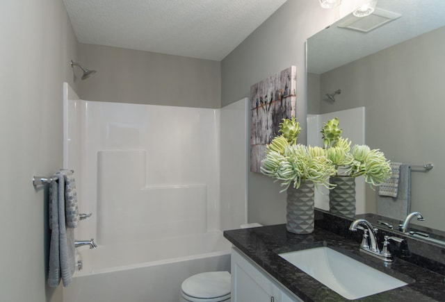 full bathroom with vanity, a textured ceiling, bathing tub / shower combination, and toilet