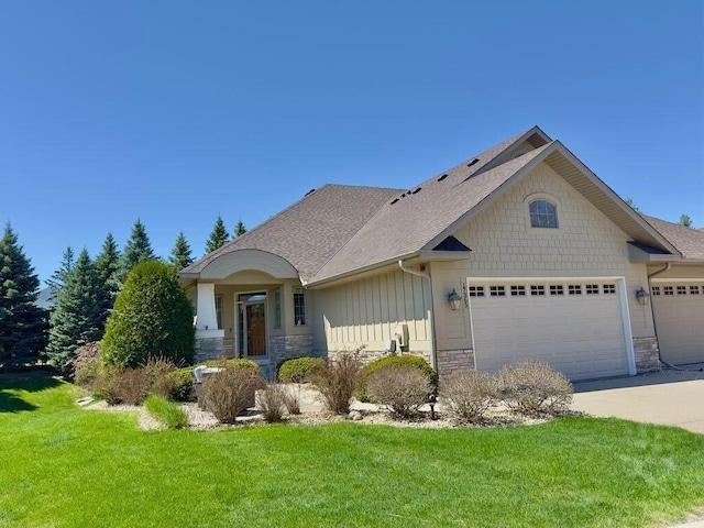 17365 Hanson Ct, Eden Prairie, MN 55347 - craftsman-style home with stone siding, a garage, a front lawn, concrete driveway, and a shingled roof