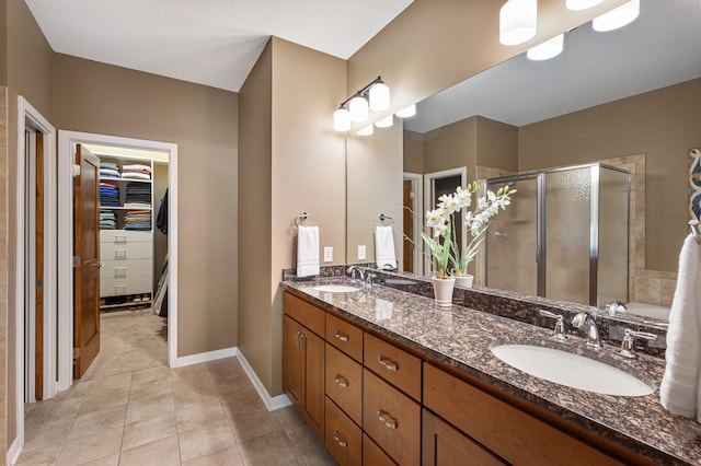 17365 Hanson Ct, Eden Prairie, MN 55347 - full bath featuring a stall shower, a walk in closet, double vanity, tile patterned flooring, and baseboards
