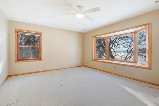 spare room with light colored carpet and ceiling fan