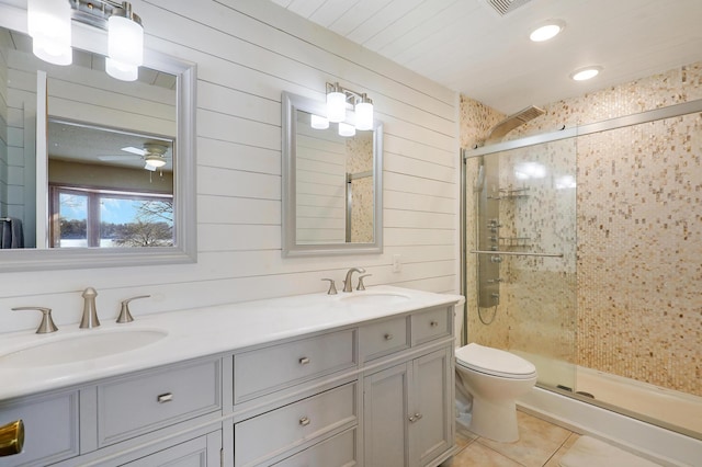 bathroom with tile patterned flooring, vanity, walk in shower, ceiling fan, and toilet