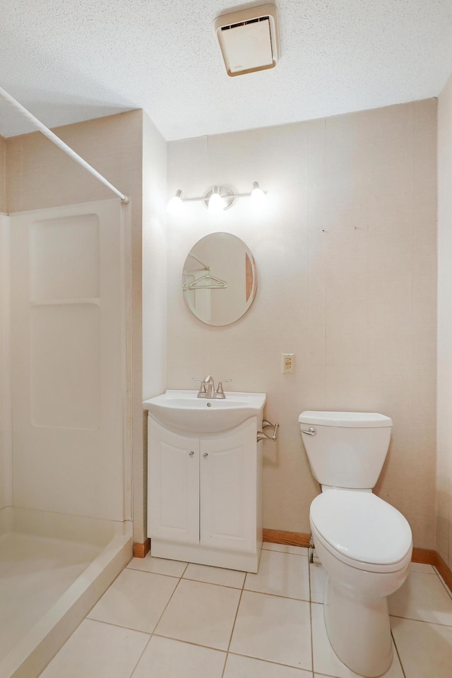 bathroom with tile patterned floors, toilet, vanity, and a shower