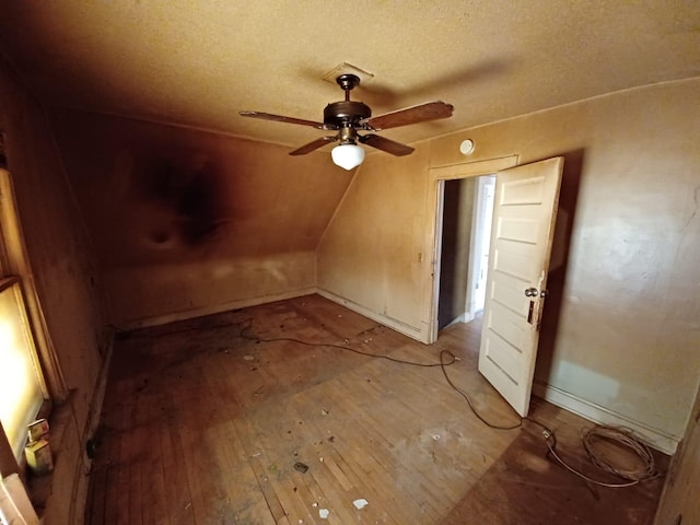 bonus room featuring ceiling fan, vaulted ceiling, and a textured ceiling