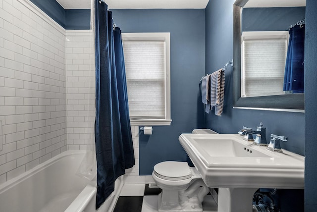 full bathroom featuring toilet, tile patterned flooring, shower / bath combo, and baseboards