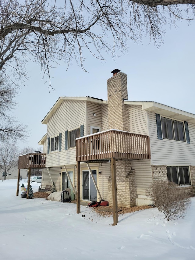 snow covered property with a deck