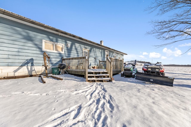 snow covered house featuring a wooden deck