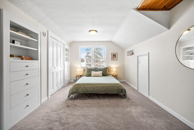 bedroom with lofted ceiling, carpet floors, and a textured ceiling