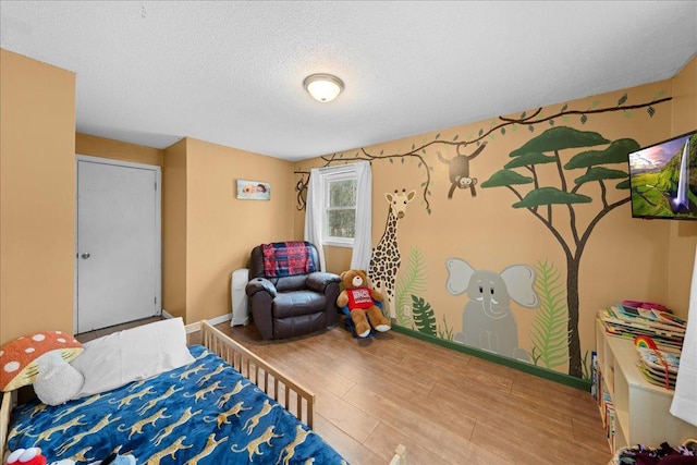 bedroom with hardwood / wood-style floors and a textured ceiling