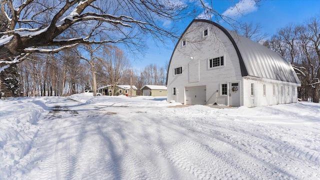 snow covered rear of property with a garage