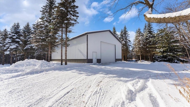 snow covered structure with a garage