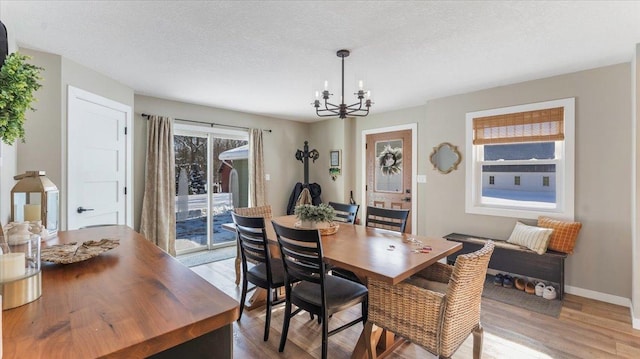 dining space featuring a chandelier, hardwood / wood-style floors, and a textured ceiling