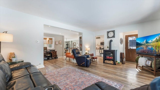 living room with a wood stove and light wood-type flooring