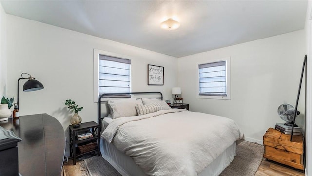 bedroom featuring multiple windows and light hardwood / wood-style flooring