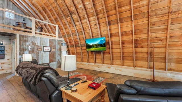 living room featuring wood-type flooring, wooden ceiling, high vaulted ceiling, and wood walls