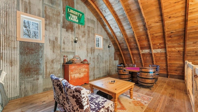 living area with lofted ceiling with beams, hardwood / wood-style flooring, and wood ceiling