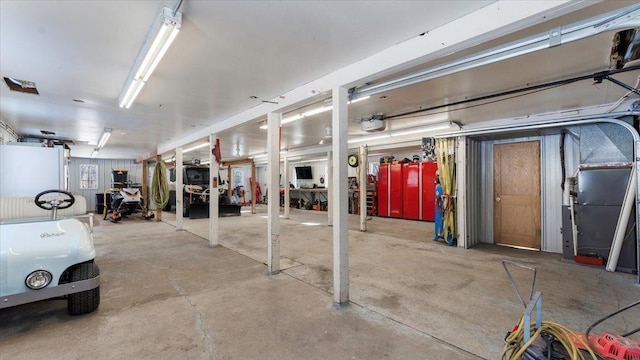 garage featuring a garage door opener and heating unit