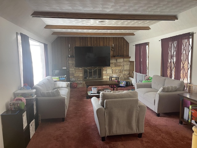 carpeted living room featuring a stone fireplace and vaulted ceiling with beams