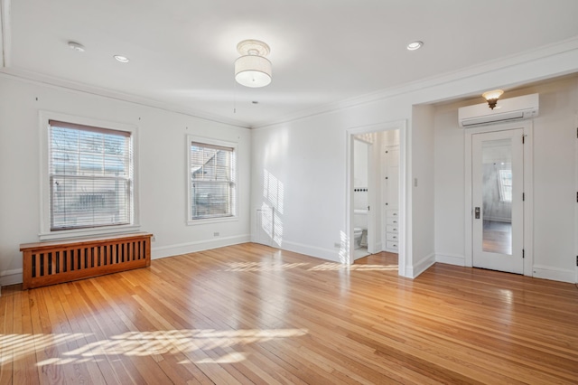 unfurnished room with baseboards, ornamental molding, light wood-type flooring, a wall mounted AC, and recessed lighting