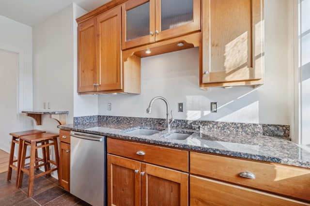 kitchen featuring dark stone counters, a sink, brown cabinets, dishwasher, and glass insert cabinets