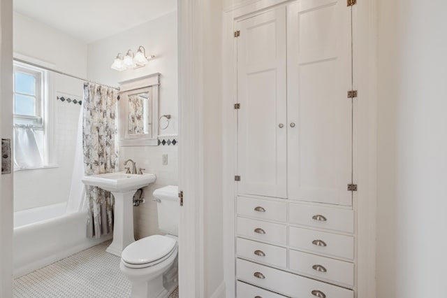 full bath with toilet, a wainscoted wall, tile walls, tile patterned floors, and shower / bathtub combination with curtain