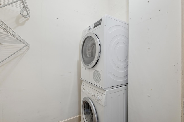 washroom featuring stacked washer and dryer and laundry area