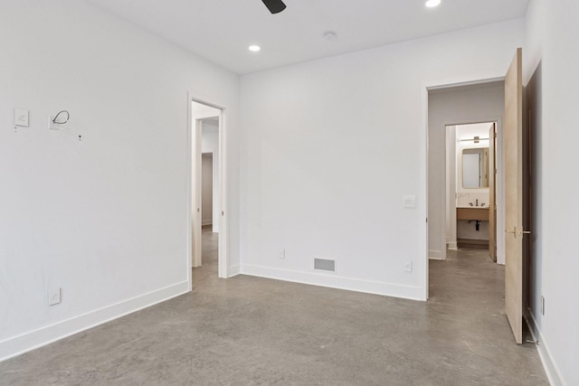 unfurnished bedroom featuring baseboards, concrete floors, and recessed lighting