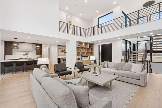 living room featuring light wood finished floors, stairway, built in features, and recessed lighting